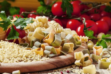 Three-color pasta in the shape of hearts on a wooden table