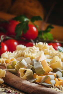 Three-color pasta in the shape of hearts on a wooden table