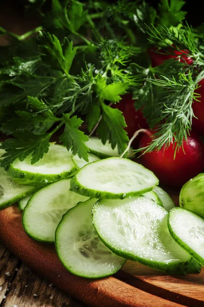 Rodajas de pepino fresco, perejil, eneldo sobre fondo de madera — Foto de Stock