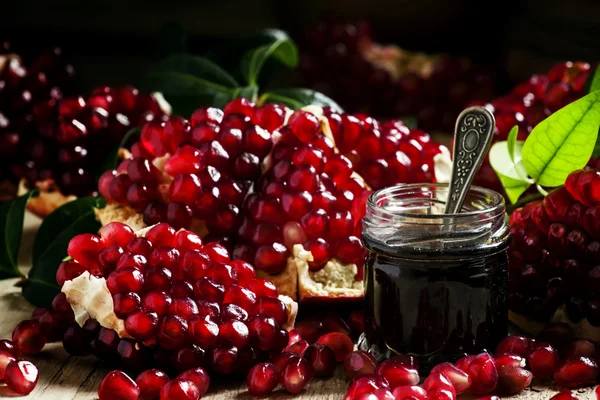 Homemade pomegranate jam in a glass jar with a spoon — ストック写真