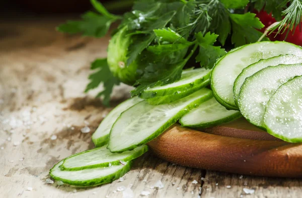 Rodajas de pepino fresco, perejil, eneldo sobre fondo de madera — Foto de Stock