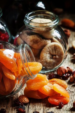 Dried apricots in a glass jar on a dark wooden background  