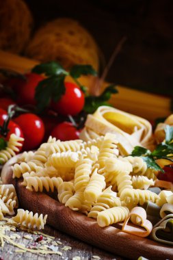 Italian food: pasta spiraline, herbs, tomatoes
