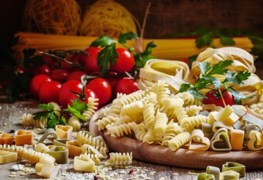Italian food: pasta spiraline, herbs, tomatoes