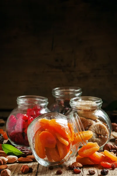 Dried apricots in a glass jar on a dark wooden background — 스톡 사진