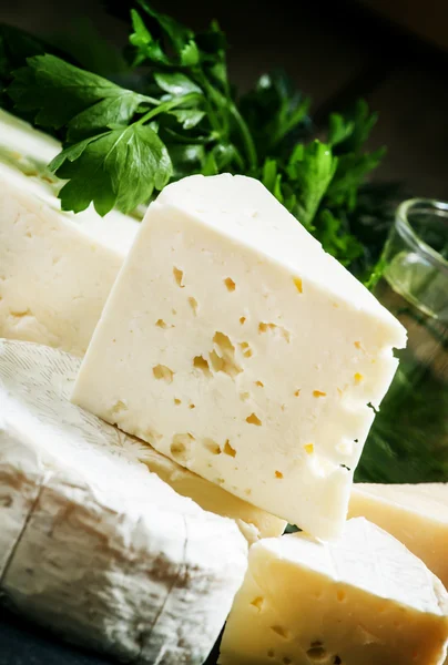 Sortimento de queijo em um fundo escuro — Fotografia de Stock