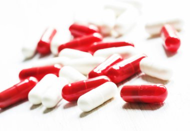 Kapsül Beyaz ahşap zemin üzerinde kırmızı ve beyaz tabletler