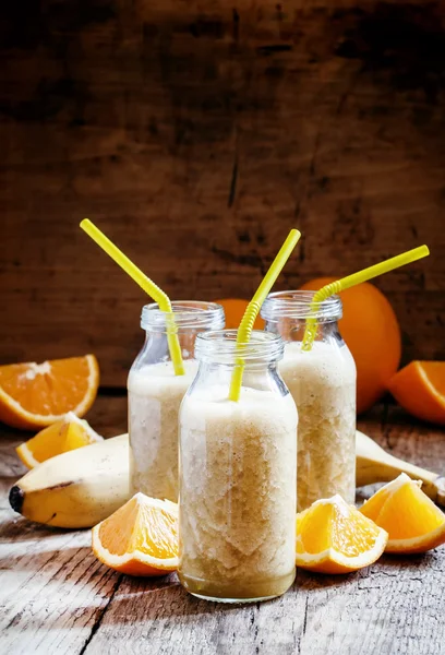 Batido de laranja de banana útil em garrafas de vidro — Fotografia de Stock