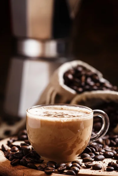 Kaffee mit Milch, Kaffeemaschine, Kaffeebohnen, dunkel getöntes Image — Stockfoto