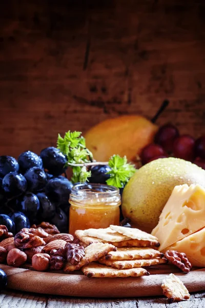 Snack plate: uvas, peras, avellanas, almendras, nueces, queso Maasdam y miel — Foto de Stock