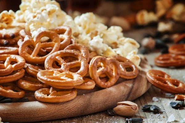 Palhas salgadas em forma de pretzels, pipocas e outros salgados — Fotografia de Stock