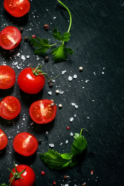 Cortar los tomates cherry sobre un fondo negro — Foto de Stock