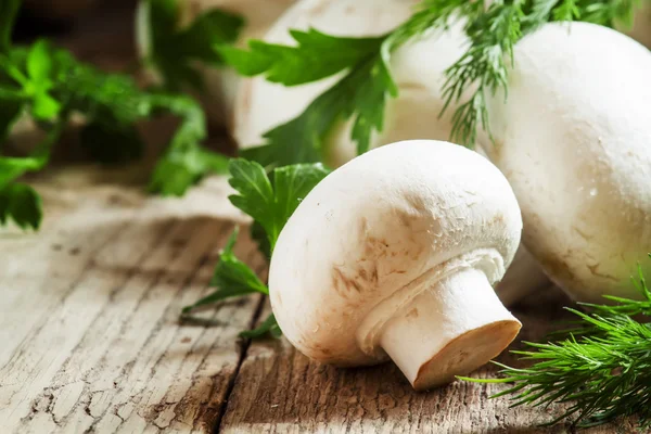 Champiñones de champiñones blancos, eneldo, perejil sobre una vieja mesa de madera —  Fotos de Stock