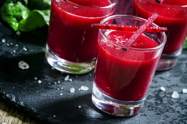 Rode bieten sap in glazen op een donkere achtergrond — Stockfoto
