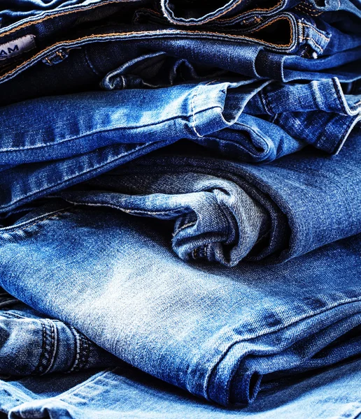 Drelich tło, niektóre dżinsy spodnie na stole — Zdjęcie stockowe