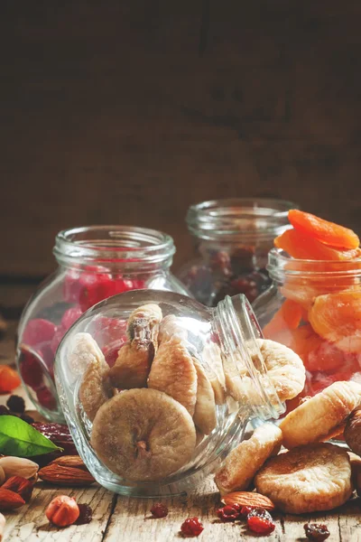 Deliciosos figos secos em um jarros de vidro na velha mesa de madeira — Fotografia de Stock