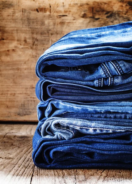 Latar belakang Denim, beberapa celana jeans di atas meja — Stok Foto