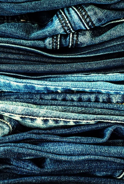 Джинсовий фон, штани з джинсами на столі — стокове фото