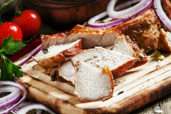 Pedaços de carne de porco grelhada em tábua de corte de madeira — Fotografia de Stock