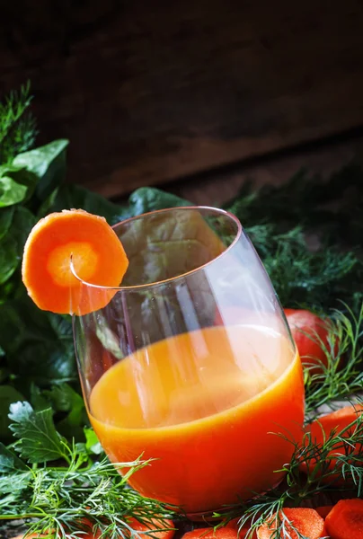 Морковный коктейль в большом стакане, украшенном ломтиком моркови — стоковое фото