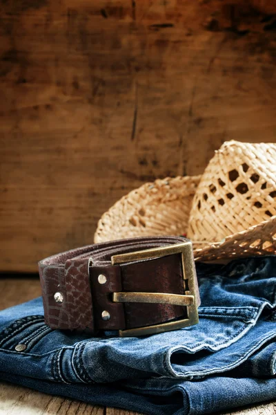 Jeans, straw hat, leather belt - women's clothes in cowboy country style