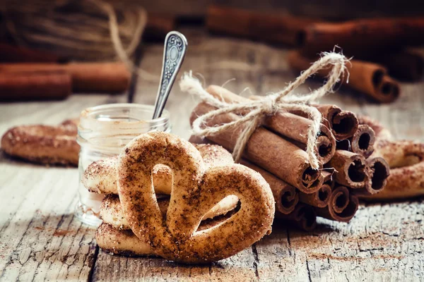 Pretzels met gemalen kaneel, kaneel stokken, bruine rietsuiker — Stockfoto