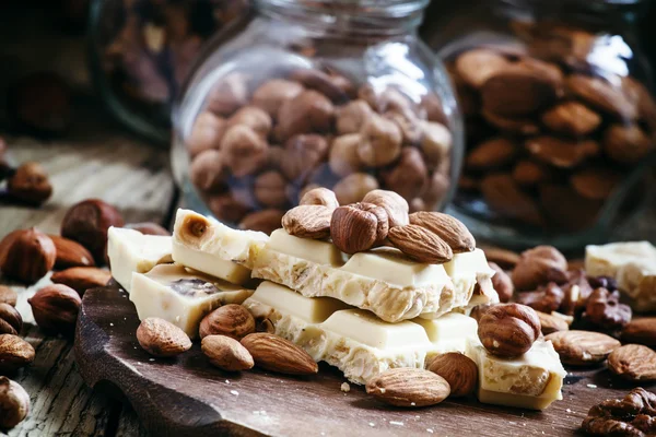 Witte chocolade met assortiment noten: amandelen, hazelnoten, walnoten — Stockfoto