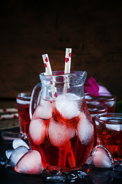 Red drink in a pitcher with ice in the shape of hearts