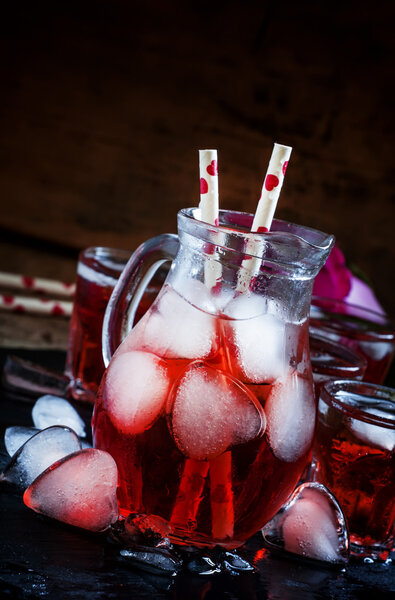 Red drink in a pitcher with ice in the shape of hearts