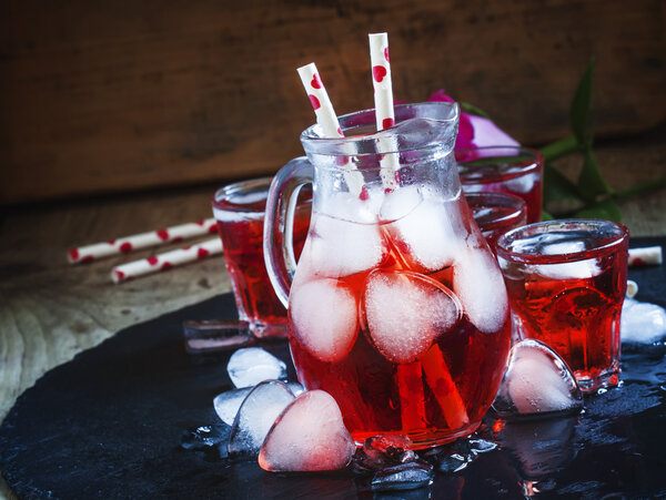 Red drink in a pitcher with ice in the shape of hearts