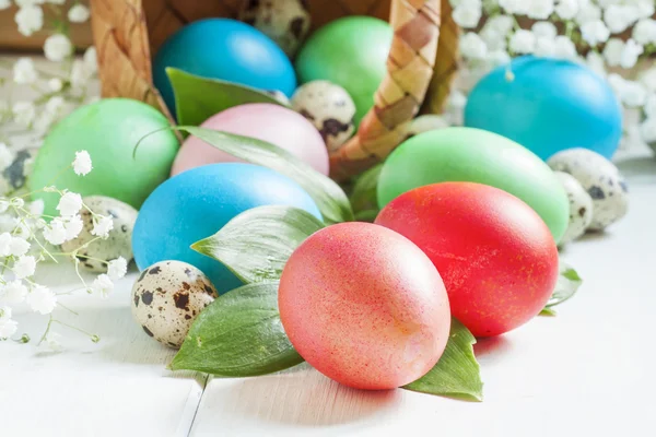 Çok renkli Paskalya yumurtaları bir hasır sepet dışarı rulo — Stok fotoğraf