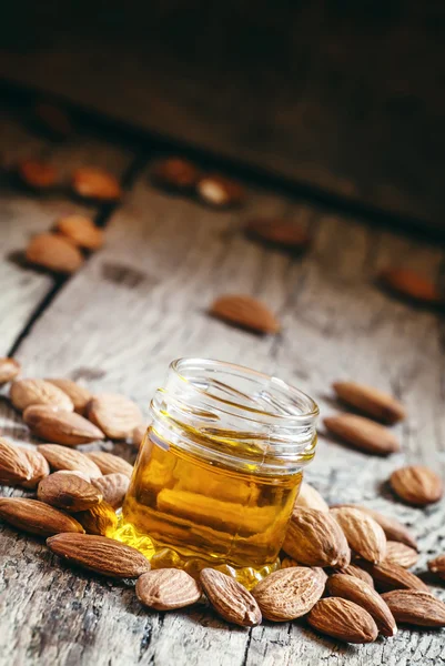 Almond oil in a small jar of almonds and nuts — Stock Photo, Image