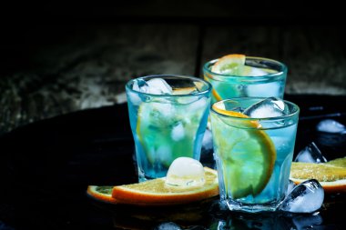 Mavi kokteyl buz küpleri ve portakal dilimleri ile