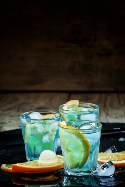 Cocktail blu con cubetti di ghiaccio e fette di arancia — Foto Stock