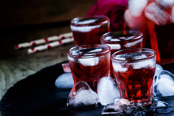 Red cocktail with ice in heart shape 