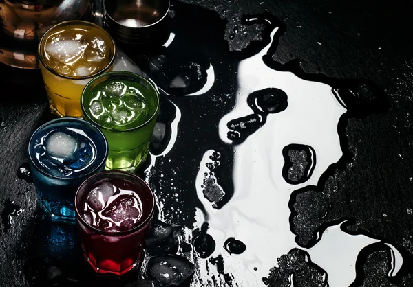 Blå, röda, gula och gröna drinkar med is — Stockfoto