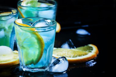 Mavi kokteyl buz küpleri ve portakal dilimleri ile