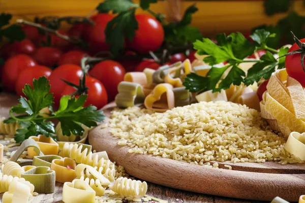 Сухая итальянская паста в виде букв, разнообразных макарон, вишня — стоковое фото