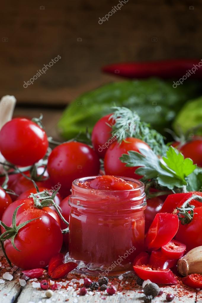 Tomato ketchup hot sauce with chili pepper and cherry tomatoes Stock