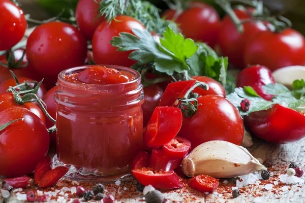 Tomato ketchup hot sauce with chili pepper and cherry tomatoes — Stock Photo, Image