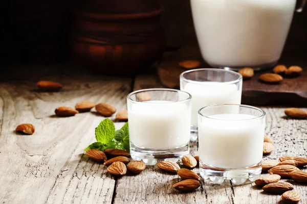 Almendras y leche, fondo de madera viejo — Foto de Stock