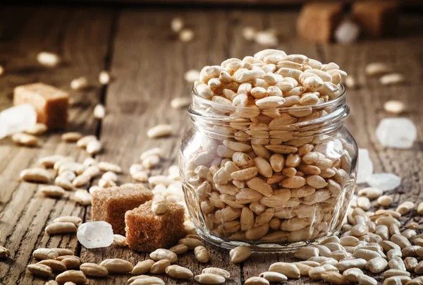 Sweet puffed rice with caramel in a glass jar — Stock Photo, Image