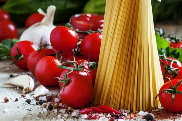 Esparguete de macarrão seco italiano com tomates e ervas frescas — Fotografia de Stock