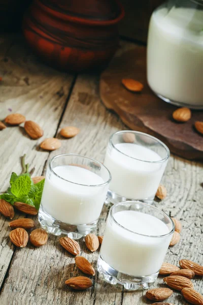 Mandeln und Milch, alter hölzerner Hintergrund — Stockfoto