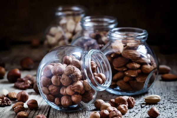 Hazelnoten in een glazen pot, donker getinte afbeelding — Stockfoto