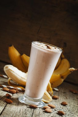 Muz smoothie büyük bir bardakta süt ile zemin badem 