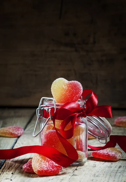 Fruit jelly hearts in a glass jar — Stock Photo, Image
