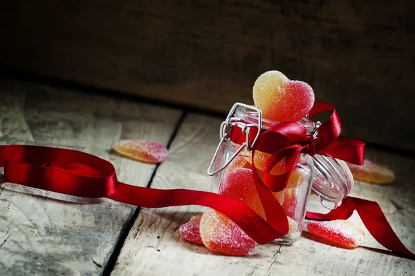 Fruit jelly hearts in a glass jar — Stock Photo, Image