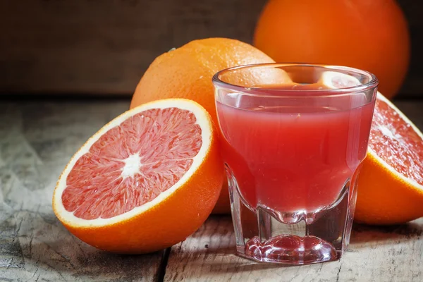 Zumo de naranjas sicilianas rojas en un vaso grande —  Fotos de Stock