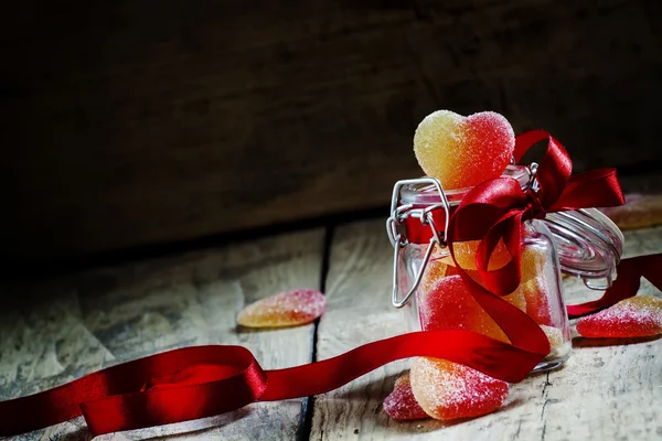 Fruit jelly hearts in a glass jar — Stock Photo, Image